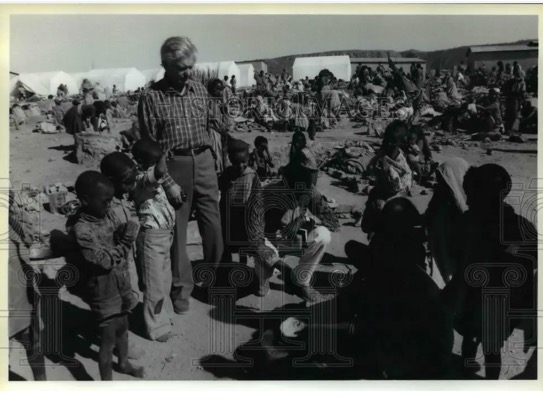 A person standing in front of a group of children
Description automatically generated